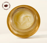 Overhead view of an open golden glass jar revealing the soft swirled texture of YOM Beauty lip balm formula with LipSafe certification logo in top corner.