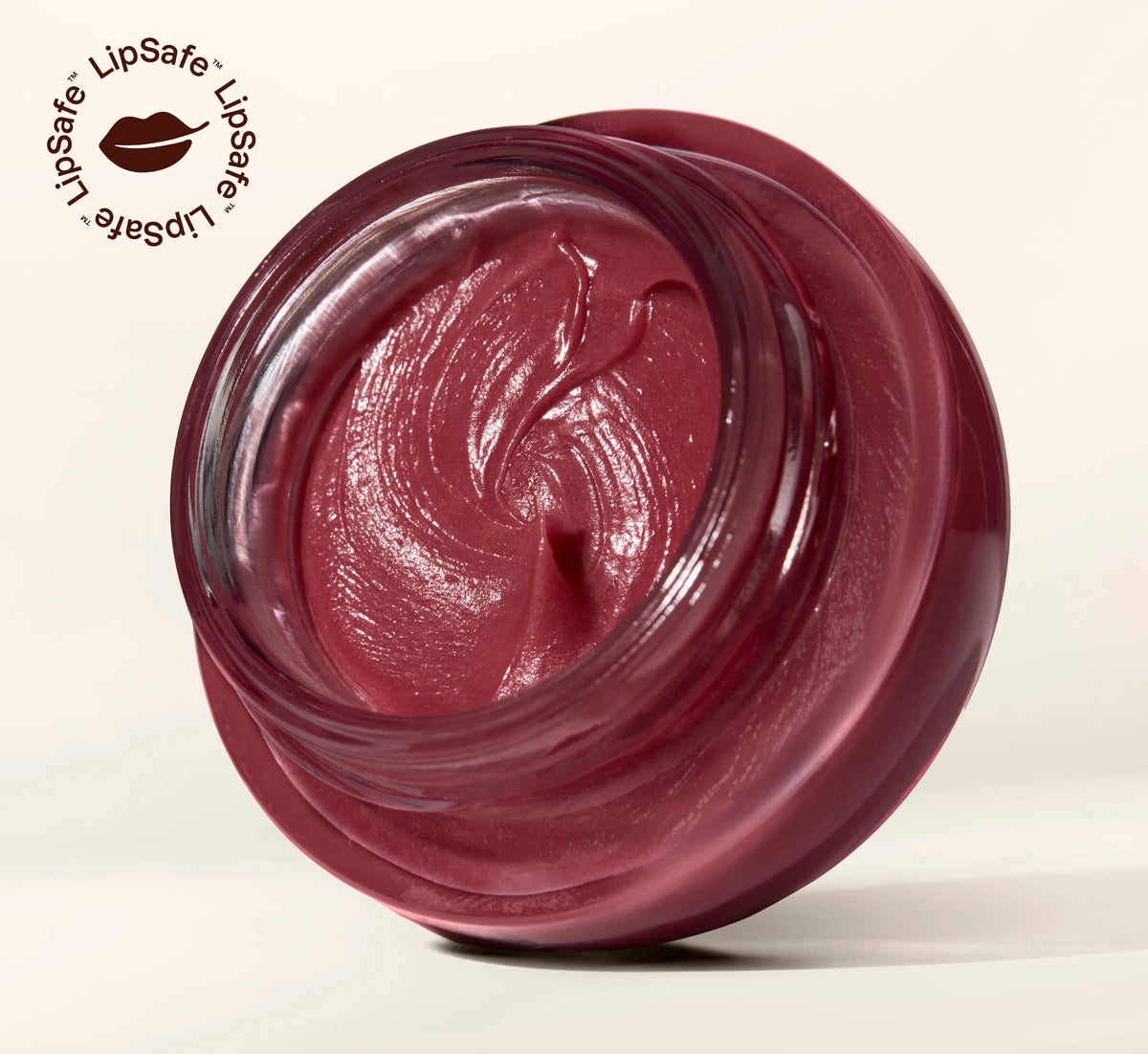 Open glass jar showing rich berry-tinted YOM Beauty lip balm formula with LipSafe certification logo in top corner.